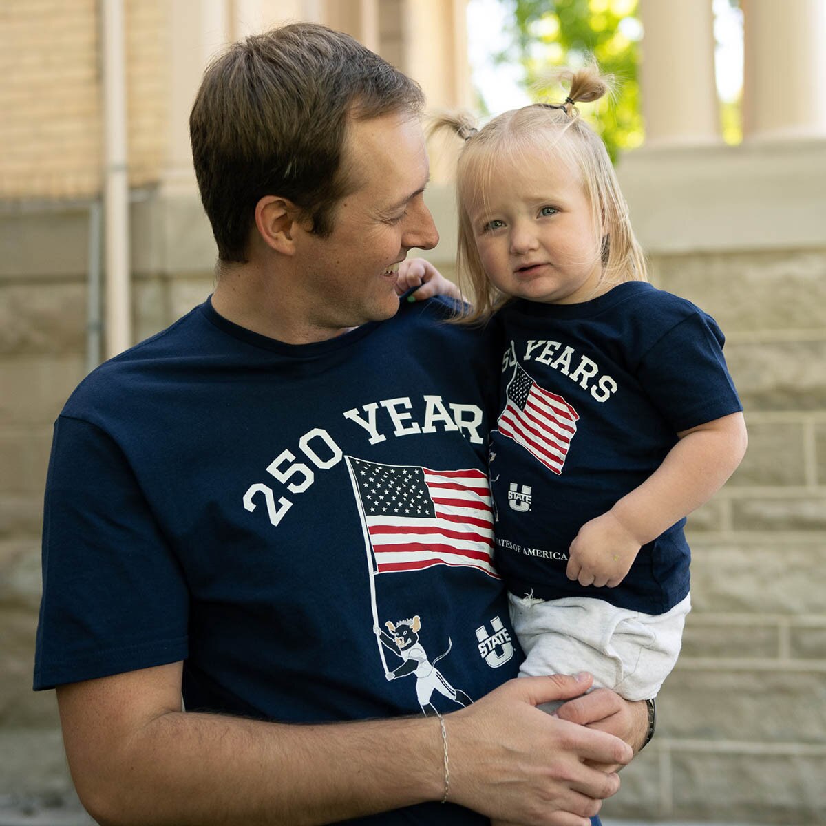 Dad and toddler daughter wearing matching patriotic t-shirts